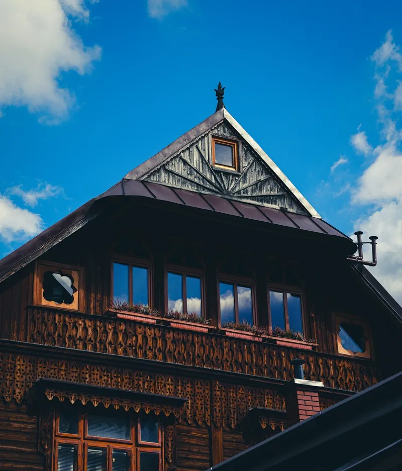 Drewniany dom w stylu zakopiańskim na tle nieba