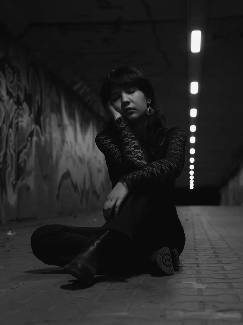 Czarno-biały portret kobiety siedzącej w tunelu