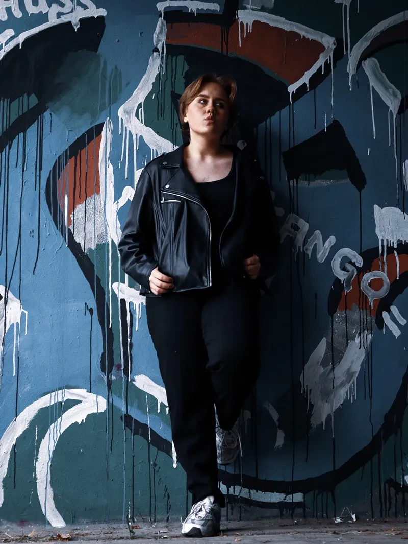 Kobieta opierająca się o ścianę z graffiti