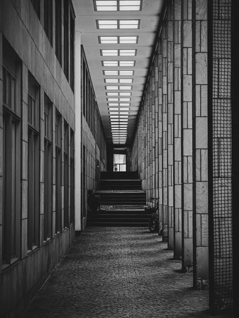 Czarno-biały, symetryczny korytarz z kolumnadą